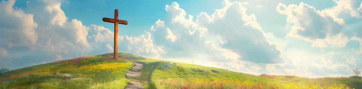 A cross on a hill with a sunny sky and green grass surrounding it.