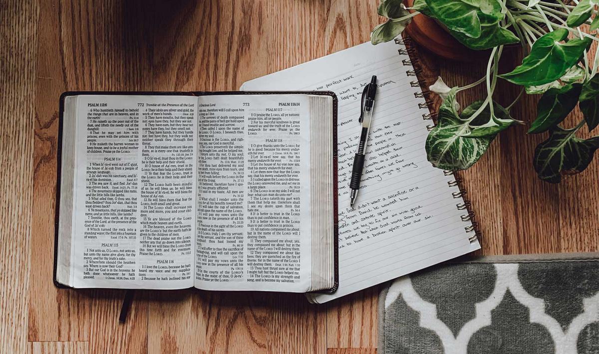 An open Bible with a notepad beside it